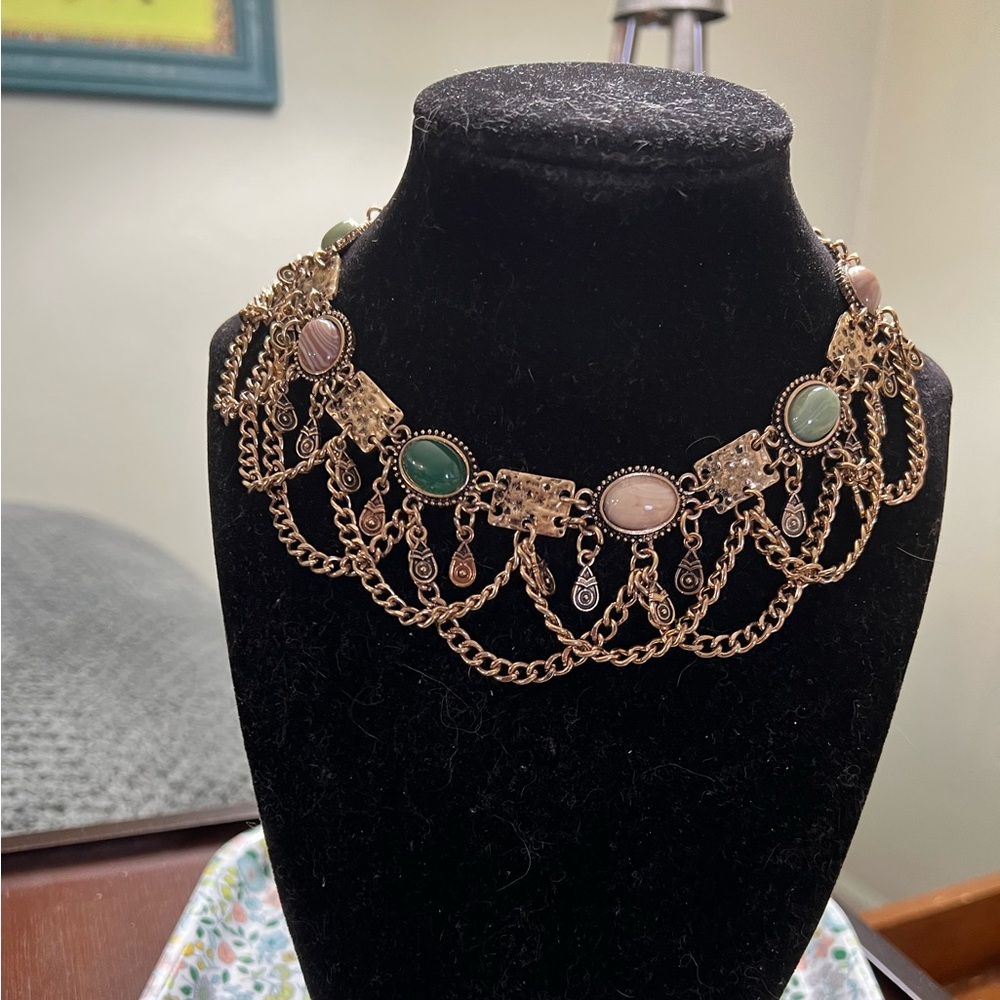 Gold tone choker necklace with fringe chains and colorful cabochons.